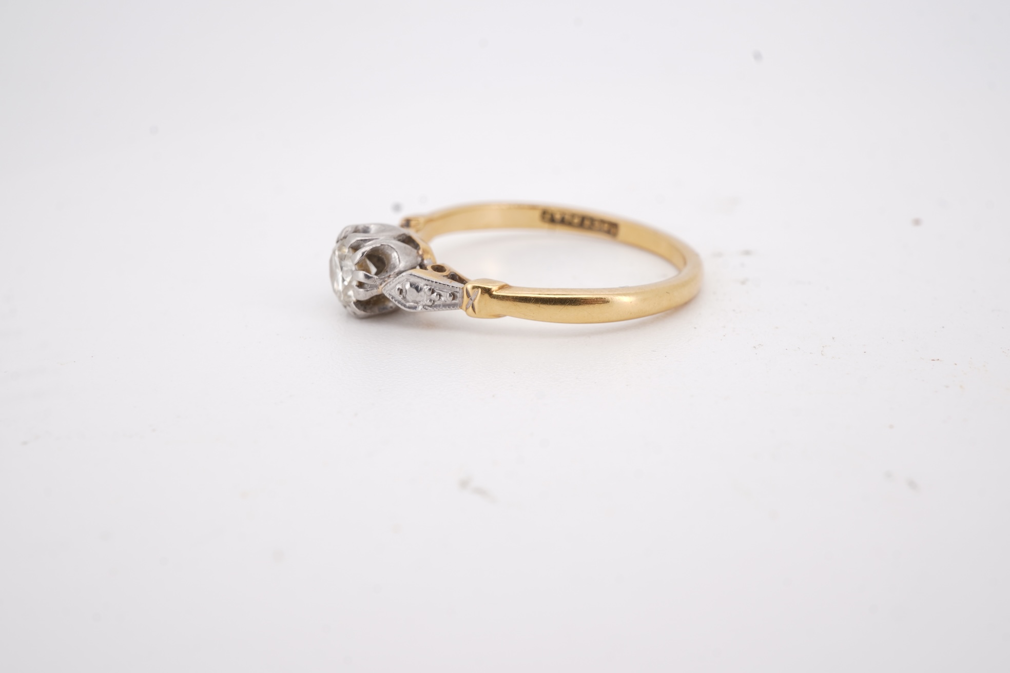 A diamond ring, set with a brilliant-cut diamond weighing approximately 0.20 carats, mounted in gold and platinum, size O1/2, stamped 18CT PLAT, gross weight approximately 2 grams, Condition: good, minor wear, diamond es